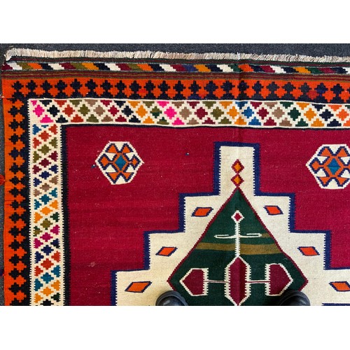 114 - A South West Persian Qashgai Kilim rug, two multi-coloured medallions, red ground, 240cm x 160cm