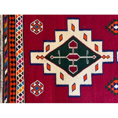 114 - A South West Persian Qashgai Kilim rug, two multi-coloured medallions, red ground, 240cm x 160cm