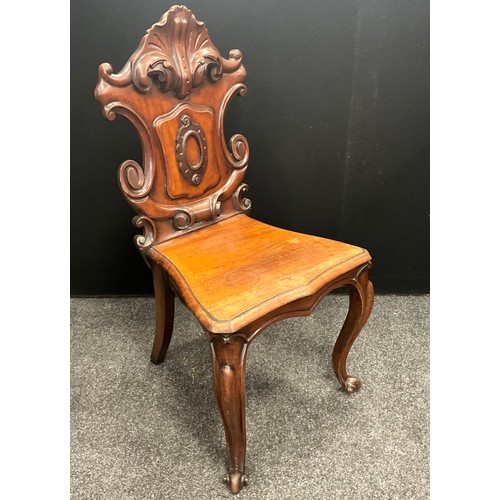 116 - A Victorian mahogany hall chair, carved shield back, serpentine seat, carved scroll end cabriole leg... 