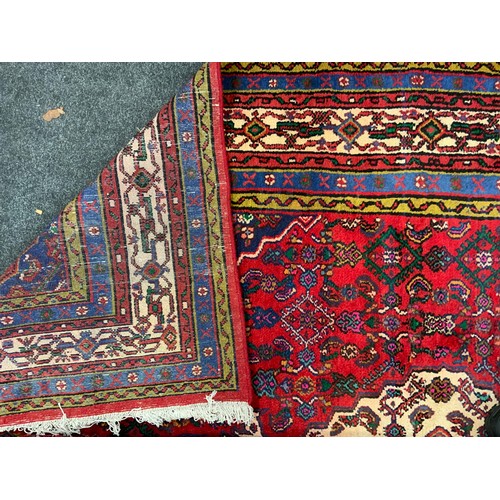 125 - A North West Persian Hamadan Carpet, multi-tones of cream, blue, green and yellow, red filed, 302cm ... 