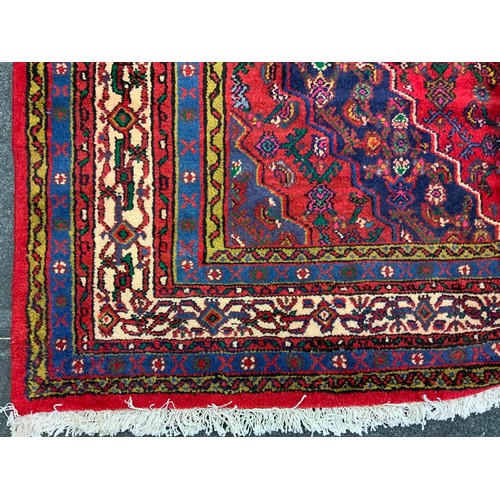 125 - A North West Persian Hamadan Carpet, multi-tones of cream, blue, green and yellow, red filed, 302cm ... 