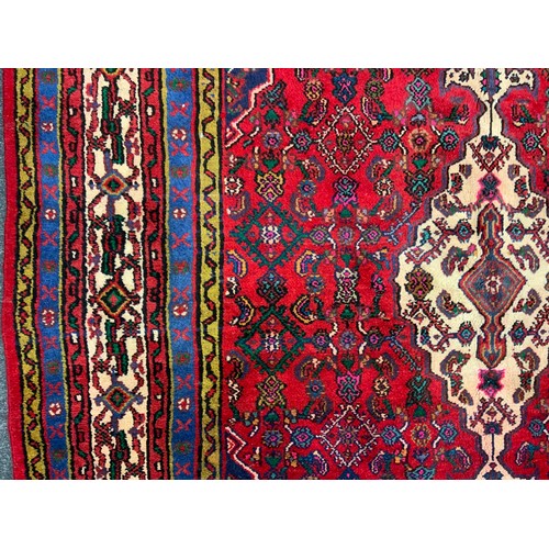 125 - A North West Persian Hamadan Carpet, multi-tones of cream, blue, green and yellow, red filed, 302cm ... 