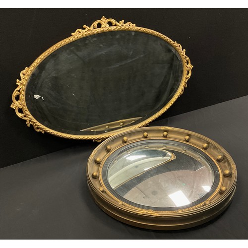 133 - A 20th century convex wall mirror, gilt frame, 47cm diameter:  another oval wall mirror, bevelled pl... 