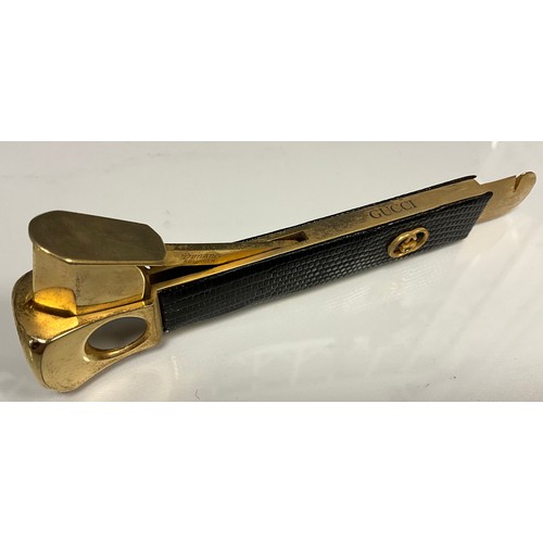 213 - A Gucci gilt metal leather mounted cigar cutter, marked Dottatus, 15cm long