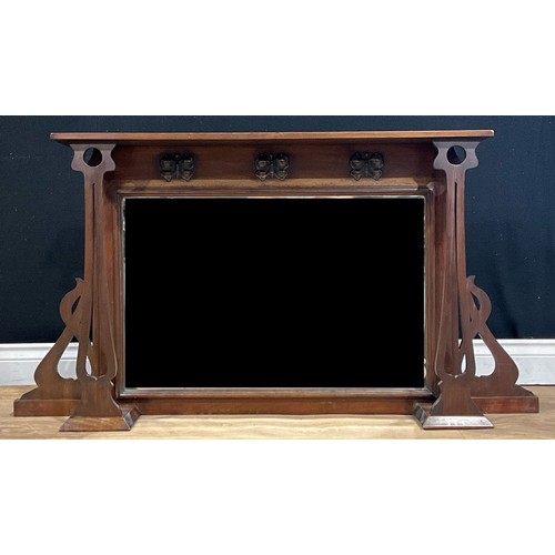 632 - An Arts & Crafts period mahogany chimney glass, bevelled mirror plate, Art Nouveau design supports, ... 