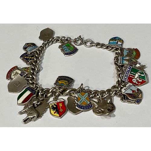 565 - A silver charm bracelet, with 23 mostly silver and enamel charms, 44.4g gross