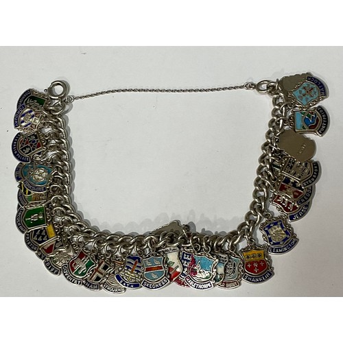 568 - A silver charm bracelet, with 34 mostly silver and enamel charms, 61.2g gross