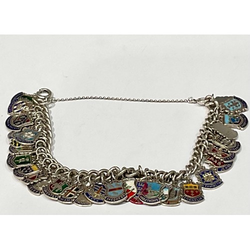 568 - A silver charm bracelet, with 34 mostly silver and enamel charms, 61.2g gross