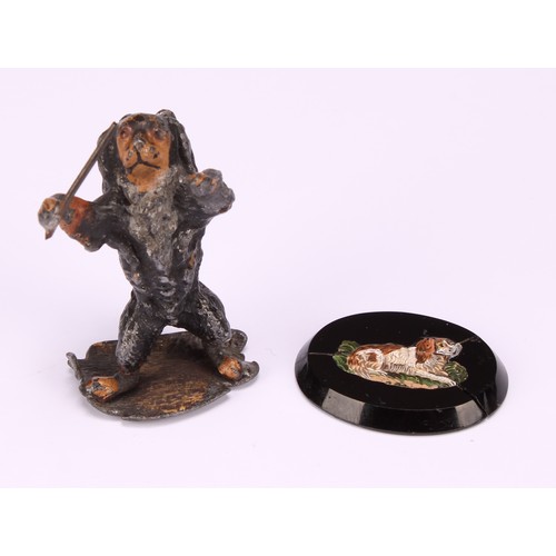 695 - An early 20th century painted metal model, Spaniel conductor, standing holding a musical baton, indi... 