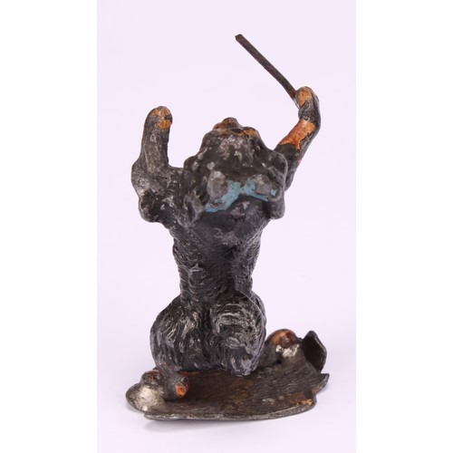 695 - An early 20th century painted metal model, Spaniel conductor, standing holding a musical baton, indi... 