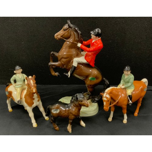 21 - A Beswick huntsman on rearing horse, 868, 24.2cm high, Boy and girl on Palomino Pony, model No. 1500... 