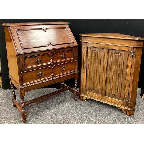 112 - An early 20th century oak bureau, 100cm high x 76cm wide x 41cm deep;  an oak corner cupboard, carve... 