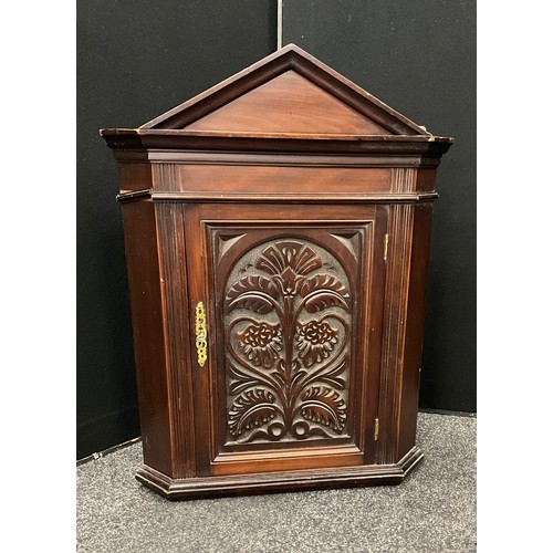 153 - A small stained pine carved wall hanging corner cupboard, single door, 71cm high, 53cm wide, 32cm de... 