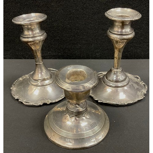 220 - A pair of Edwardian silver candlesticks, floral rims, weighted bases, 11cm high, marks worn possibly... 