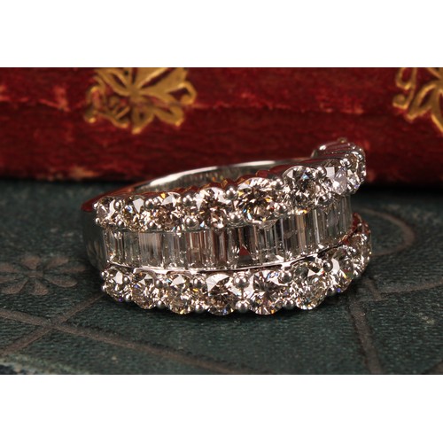 252 - A diamond and platinum ring, the central band of baguette cut stones flanked by two rows of graduate... 