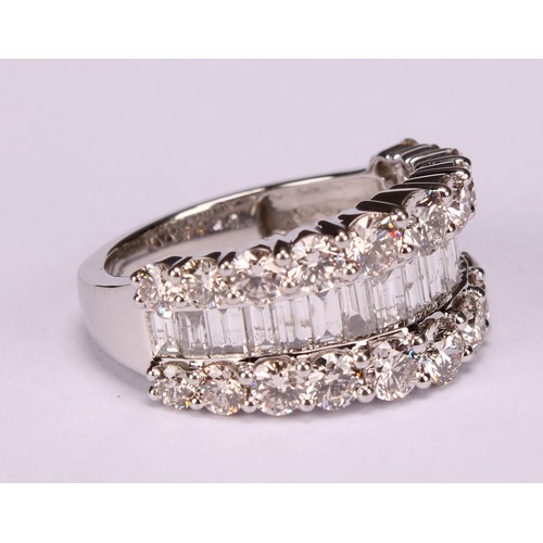 252 - A diamond and platinum ring, the central band of baguette cut stones flanked by two rows of graduate... 