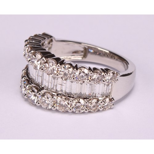 252 - A diamond and platinum ring, the central band of baguette cut stones flanked by two rows of graduate... 