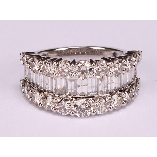 252 - A diamond and platinum ring, the central band of baguette cut stones flanked by two rows of graduate... 