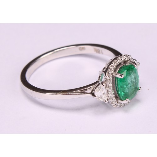 253 - An 18ct white gold emerald and diamond cluster ring, emerald 0.79ct, diamonds 0.28ct, size N