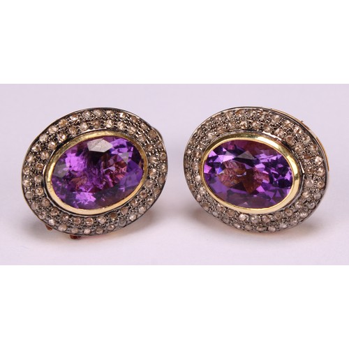 257 - A pair of cufflinks in yellow metal set with oval amethysts surrounded by round cut diamonds, the al... 