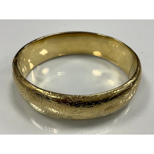 258 - A yellow metal floral decorated hinge bangle, stamped 585 to clasp, 34.4g gross