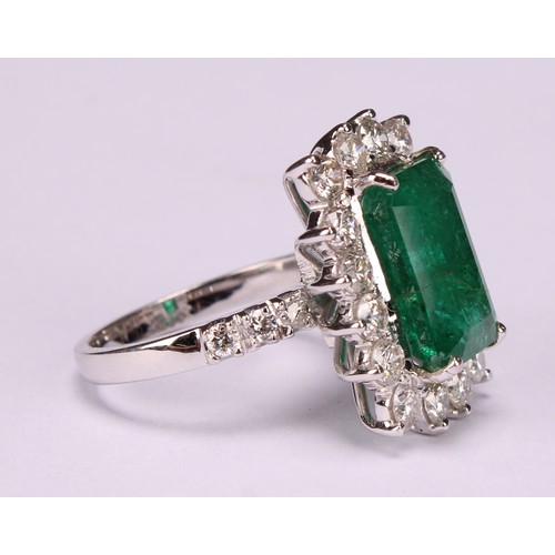 260 - An 18ct white gold emerald and diamond cluster ring, step-cut emerald, 6.01ct, round brilliant cut d... 