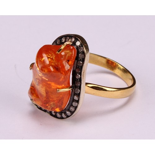 263 - An 18ct gold and silver topped ring set with a freeform mandarin garnet surrounded vby rose cut diam... 