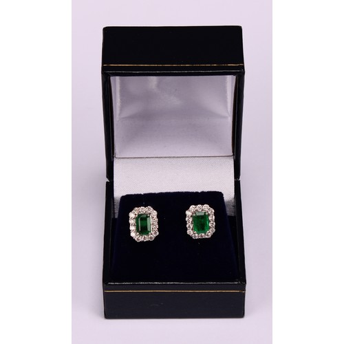 265 - A pair of 18ct white gold cluster earrings set with step-cut emeralds and round brilliant cut diamon... 