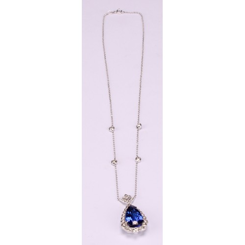 268 - An 18ct white gold pendant, set with a pear shaped tanzanite surrounded by round brilliant, pear and... 