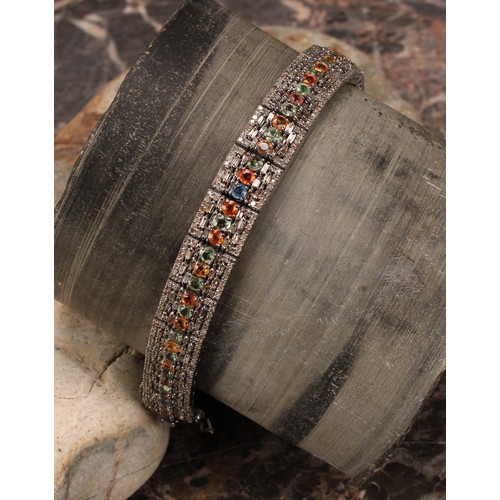 269 - An Art Deco style line bracelet set with multicoloured sapphires 
and round and baguette cut diamond... 