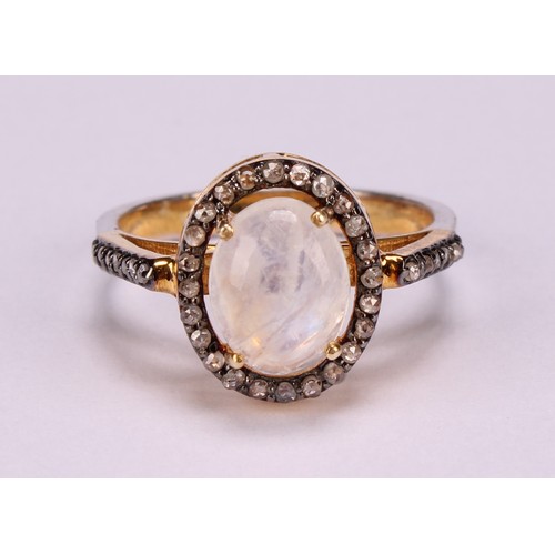 272 - A moonstone and diamond ring, the large Oval cabochon rainbow moonstone within a border of rose-cut ... 