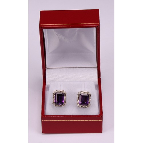 283 - A pair of 18ct white gold stud earrings, set with step-cut amethysts surrounded by round brilliant a... 