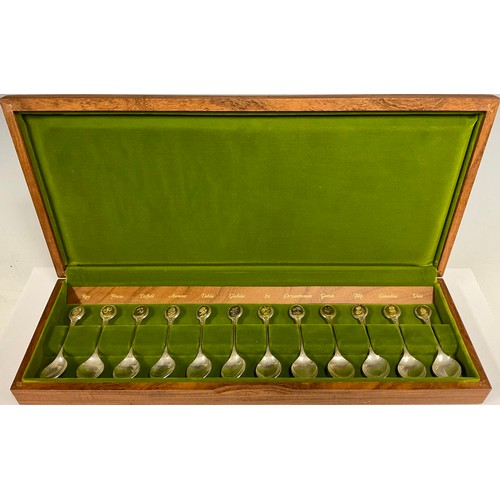 72 - A collection of twelve silver teaspoons, The Royal Horticultural Society Flower Spoons, each oval gi... 