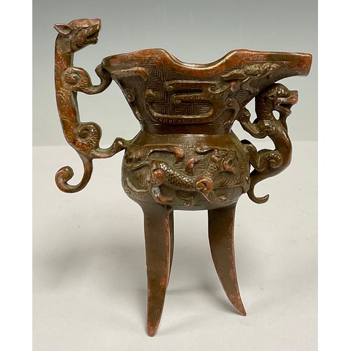 92 - A 20th century Chinese bronze tripod Jue cup, 13cm high, 11.5cm wide