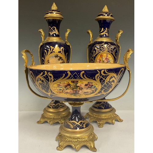 180 - A pair of contemporary Sevres style gilt metal mounted porcelain vases and stands, painted with land... 