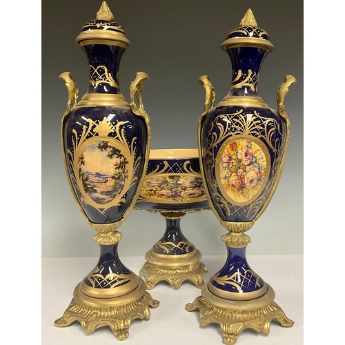 180 - A pair of contemporary Sevres style gilt metal mounted porcelain vases and stands, painted with land... 