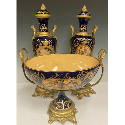 180 - A pair of contemporary Sevres style gilt metal mounted porcelain vases and stands, painted with land... 