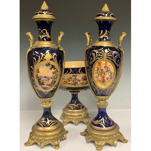 180 - A pair of contemporary Sevres style gilt metal mounted porcelain vases and stands, painted with land... 