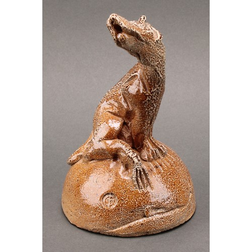 3197 - Studio pottery - a salt glazed stoneware model of a howling hound, seated upon a mound, by Ian Grego... 