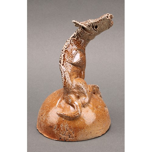 3197 - Studio pottery - a salt glazed stoneware model of a howling hound, seated upon a mound, by Ian Grego... 