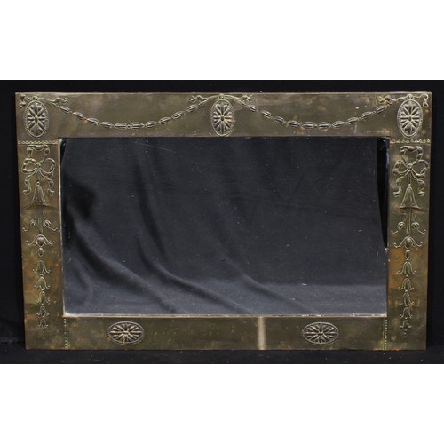 3403 - An Arts & Crafts brass mounted chimney glass, rectangular mirror plate, the frame repoussé decorated... 