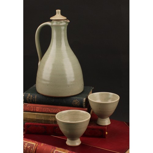 3187 - A Leach Pottery sake carafe and stopper with pair of conical sake glasses, glazed in celadon green, ... 