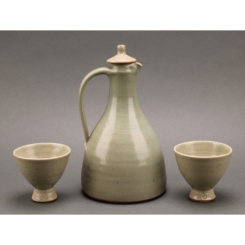 3187 - A Leach Pottery sake carafe and stopper with pair of conical sake glasses, glazed in celadon green, ... 