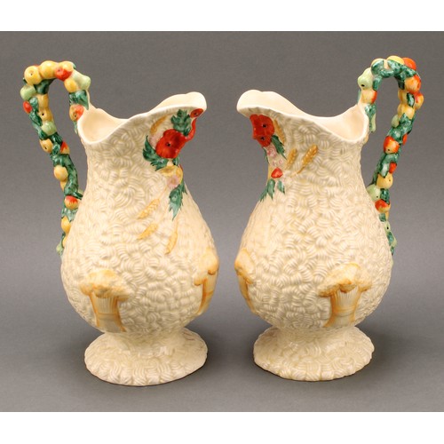 3009 - A pair of Clarice Cliff Celtic Harvest pattern jugs, moulded with wheatsheaves on a honey glaze grou... 