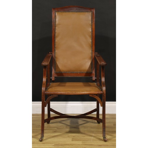 3330 - An Arts & Crafts mahogany reclining armchair, the sloping back adjustable on a baton, shaped arms wi... 