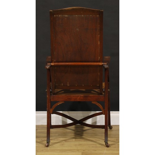 3330 - An Arts & Crafts mahogany reclining armchair, the sloping back adjustable on a baton, shaped arms wi... 