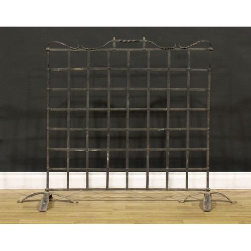 3376 - An Arts & Crafts wrought iron fire screen, of country house proportions, shaped cresting rail with t... 