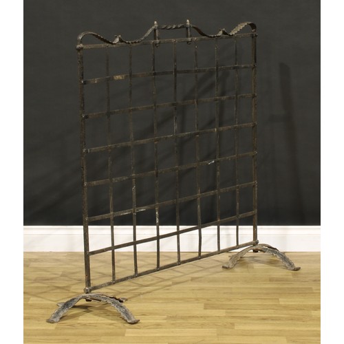 3376 - An Arts & Crafts wrought iron fire screen, of country house proportions, shaped cresting rail with t... 