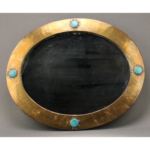 3405 - An Arts and Crafts oval planished brass wall mirror, inlaid with four turquoise glazed circular Rusk... 