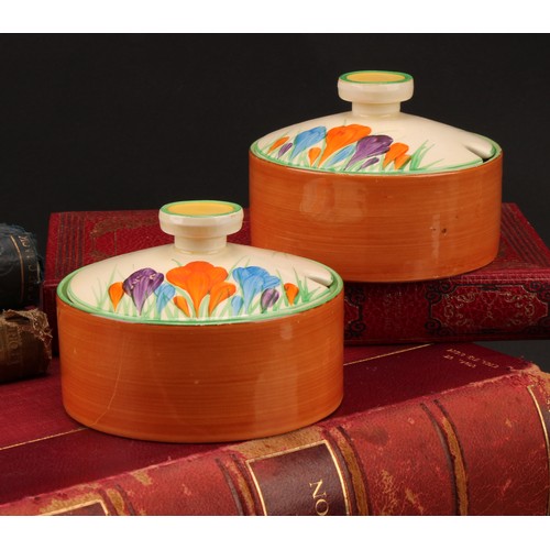 3010 - A pair of Clarice Cliff Crocus pattern compressed circular preserve jars and covers, 7cm high, Newpo... 